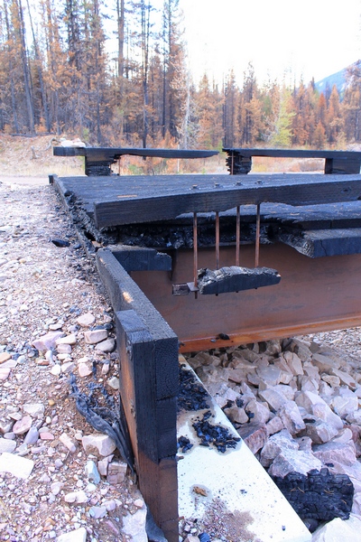 Side view of the burned wooden bridge crossing Morrell Creek on FR 4381 on the way to Morrell Falls trailhead and Pyramid Pass trailhead as it appeared 10/11/17.  The steel substructure may be salvageable.  Morrell Creek below is dry.