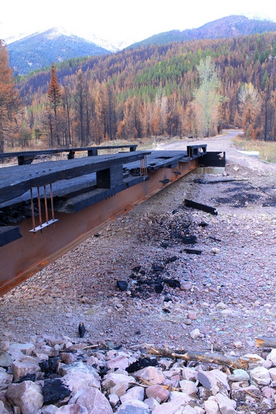 Side view of the burned wooden bridge crossing Morrell Creek on FR 4381 on the way to Morrell Falls trailhead and Pyramid Pass trailhead as it appeared 10/11/17.  The bridge and forest have sustained heavy damage in the Rice Ridge fire.  Morrell Creek below is dry.