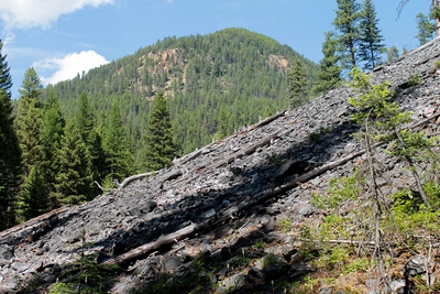 Last scree slide before the bridge crossing Falls Creek.  Our destination (unknown to us at the time of this hike) can be seen above the 5000' elevation in the distance on the side of that mountain which offered a beautiful scenic view of the canyon falls and the Ovando Valley.