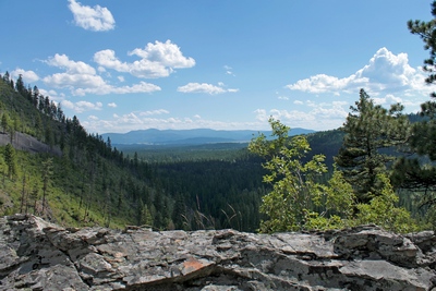 Looking south from an overlook on the Falls Creek Trail adjacent to the falls from about the 5000' elevation, a view of the Ovando valley can be seen in the distance. 